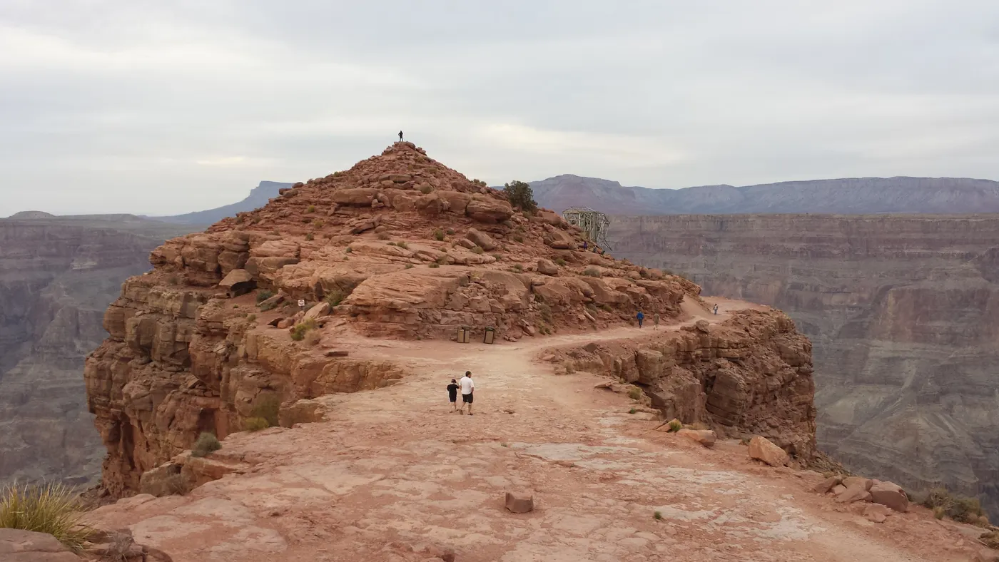 Visitors walking a rocky trail on the Grand Canyon rim